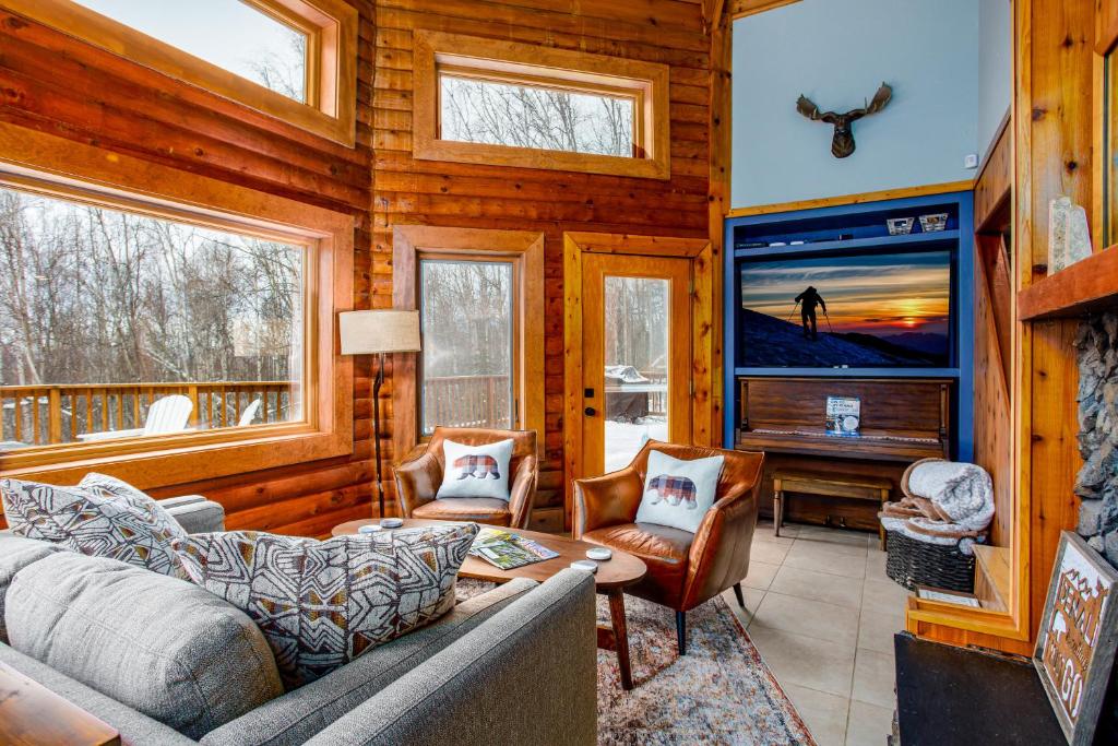 uma sala de estar com um sofá e uma televisão em Queens Birch Lodge em Eagle River