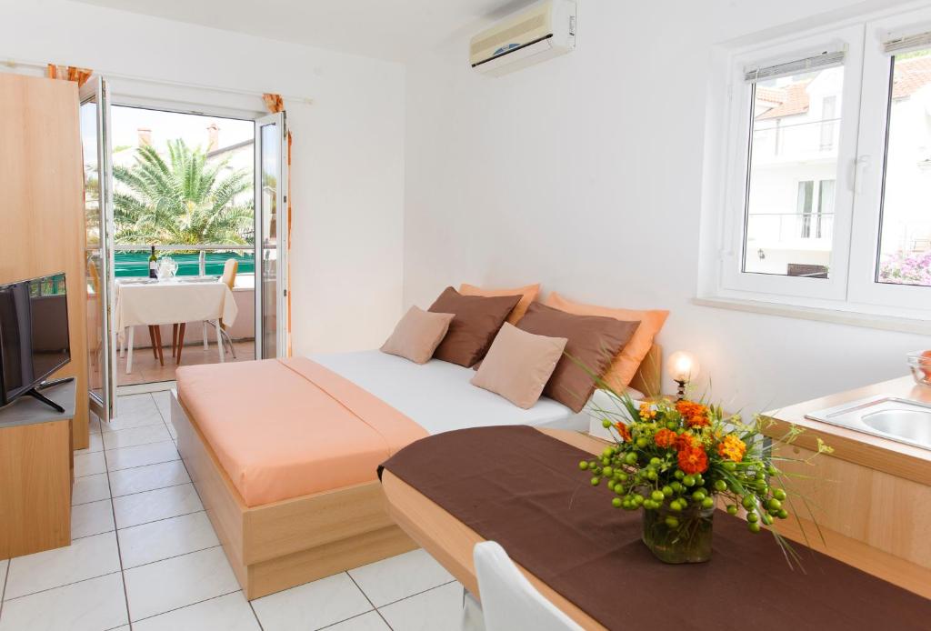 - une petite chambre avec un lit et une table fleurie dans l'établissement Room in Apartment - Cozy studio apartment for 2, à Promajna
