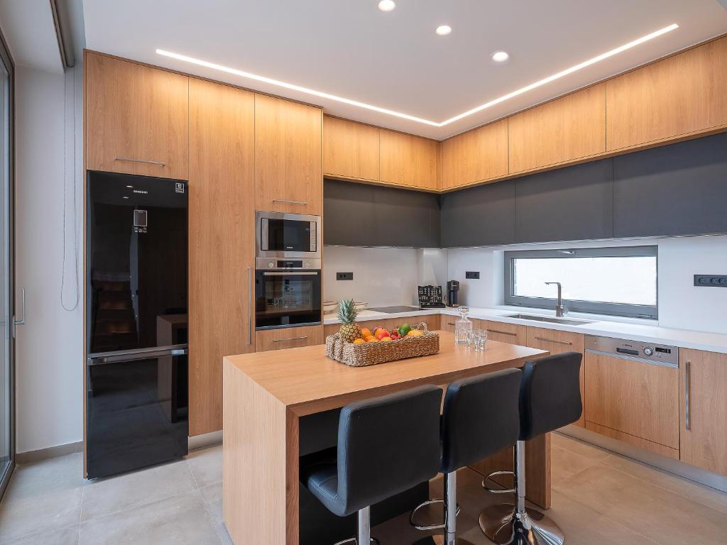 a kitchen with a island with a table and chairs at Ligaria Mare in Agia Pelagia