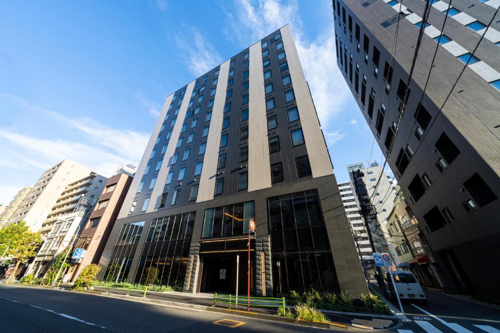 un grand bâtiment sur le côté d'une rue de la ville dans l'établissement KOKO HOTEL Tsukiji Ginza, à Tokyo