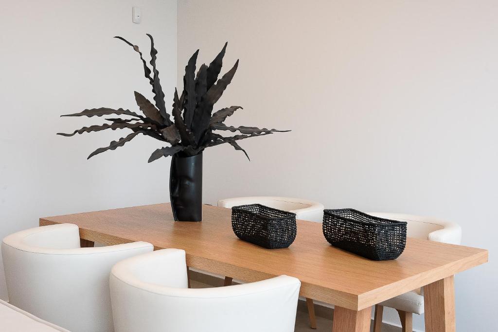 a wooden table with a vase with a plant in it at Ligaria Mare in Agia Pelagia