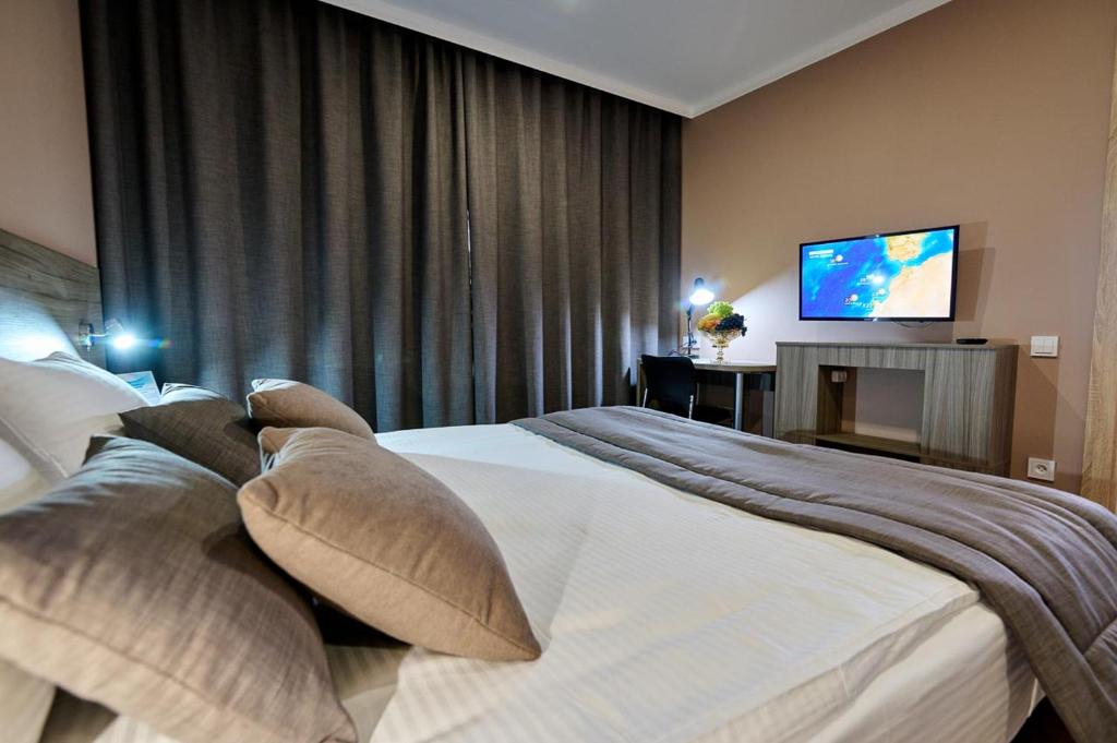 Habitación de hotel con 2 camas y TV de pantalla plana. en Victoria Hotel en Uralsk