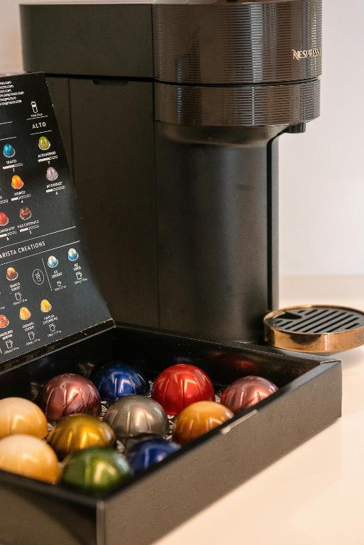 a box of colorful chocolates in front of a coffee maker at Ligaria Mare in Agia Pelagia