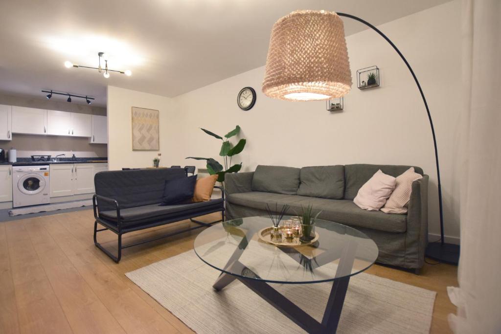 uma sala de estar com um sofá e uma mesa de vidro em Modern 2 bed Apartment- Town Centre em Northampton