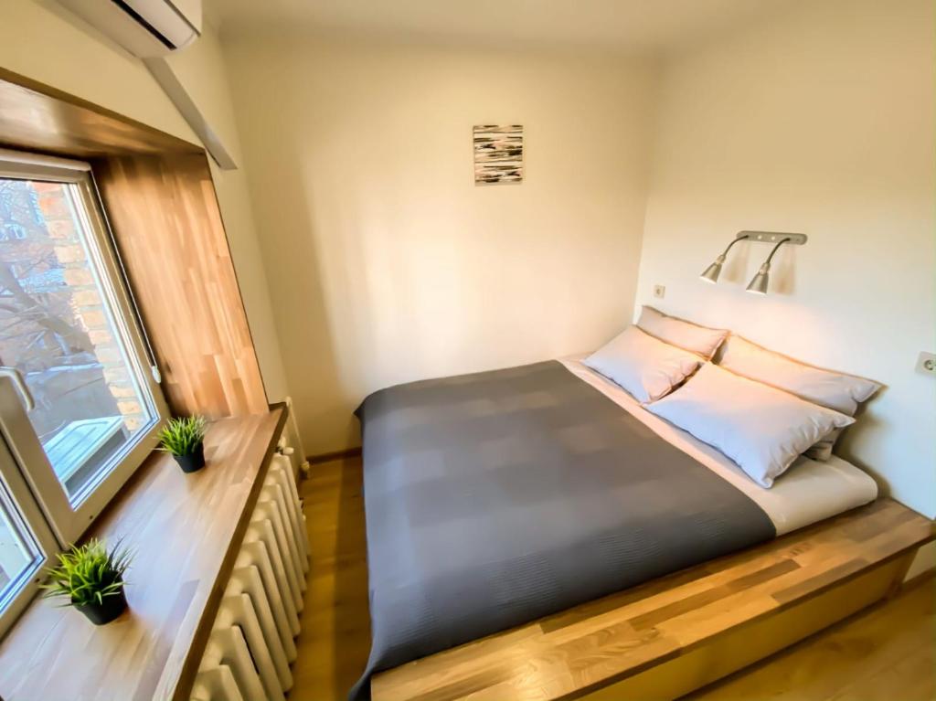 uma cama num pequeno quarto com uma janela em Mina Hotel em Vladivostok