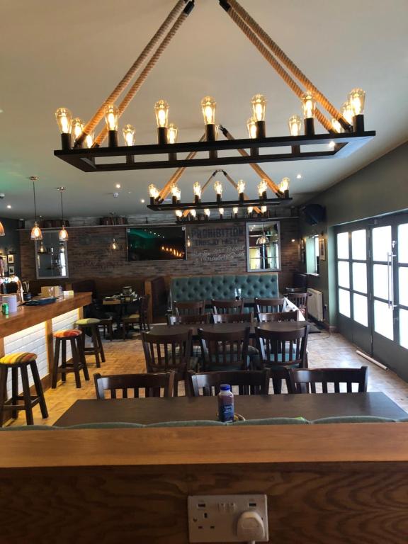 ein Restaurant mit einer Bar sowie Tischen und Stühlen in der Unterkunft Scone Arms Hotel in New Scone