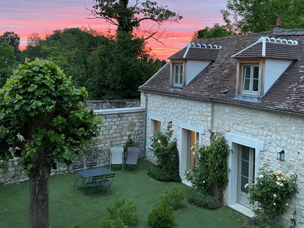 una casa con tavolo e sedie nel cortile di L'ancien Presbytère a Coye-la-Forêt