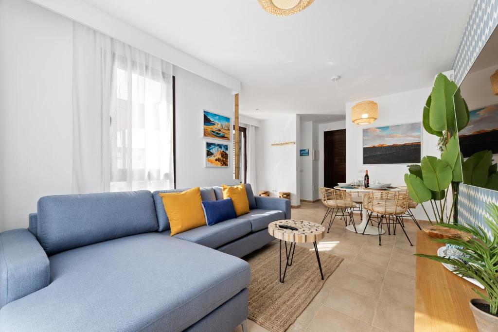 salon z niebieską kanapą i stołem w obiekcie Lanzarote Villa Arts w mieście Playa Blanca
