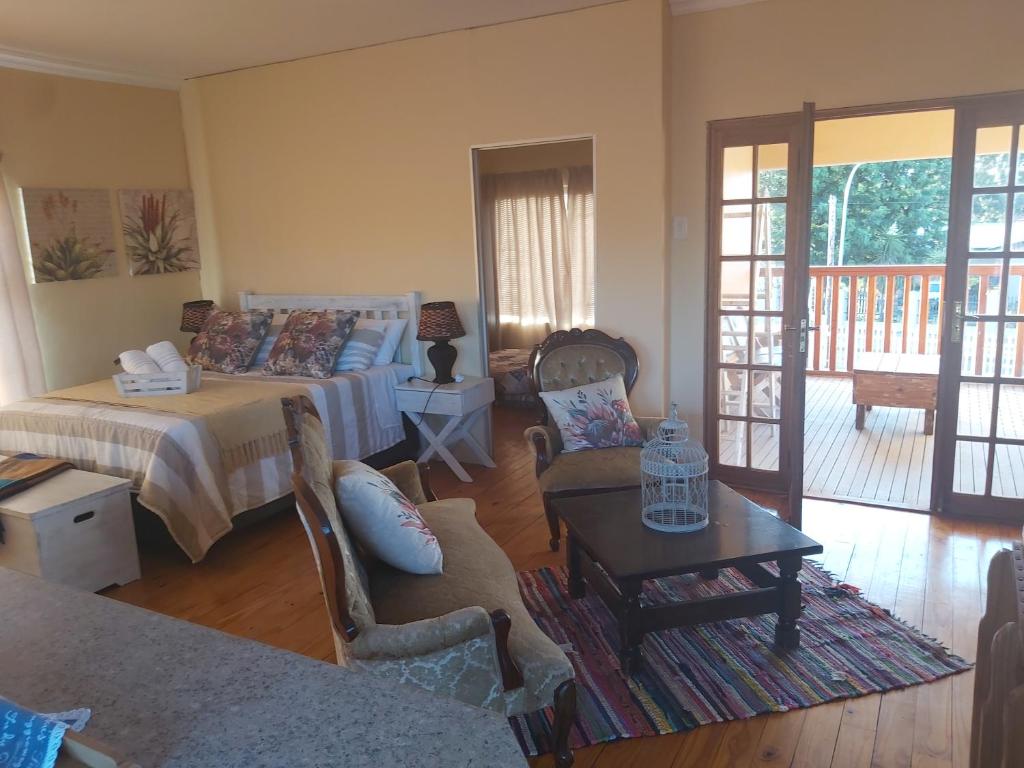 ein Wohnzimmer mit einem Bett und einem Tisch in der Unterkunft Affieplaas Selfsorg in Kimberley