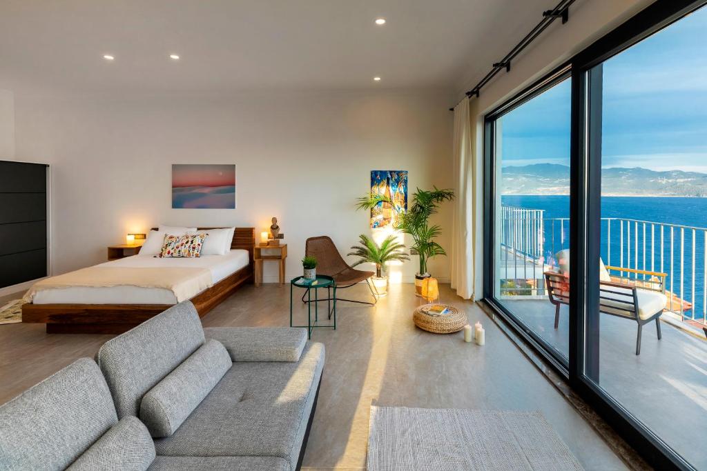 a living room with a bed and a large window at Born in Blue in Kaş
