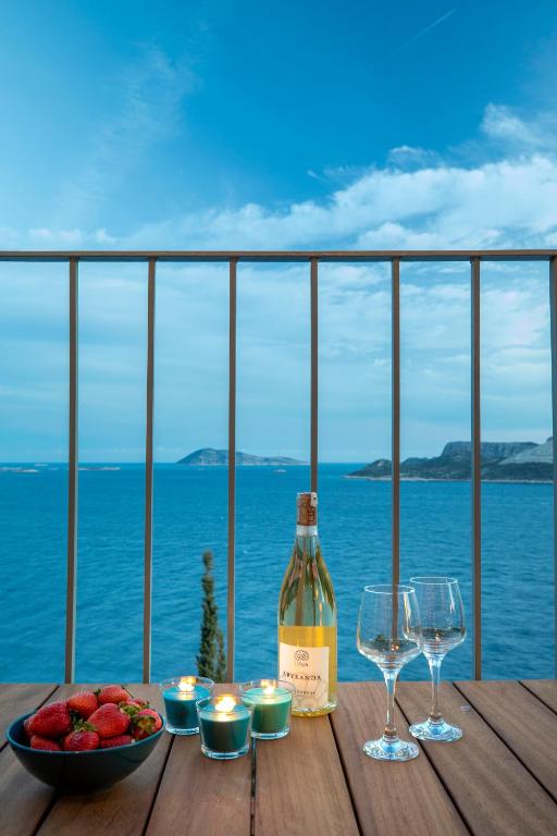 a bottle of wine sitting on a table with a bowl of fruit at Born in Blue in Kaş