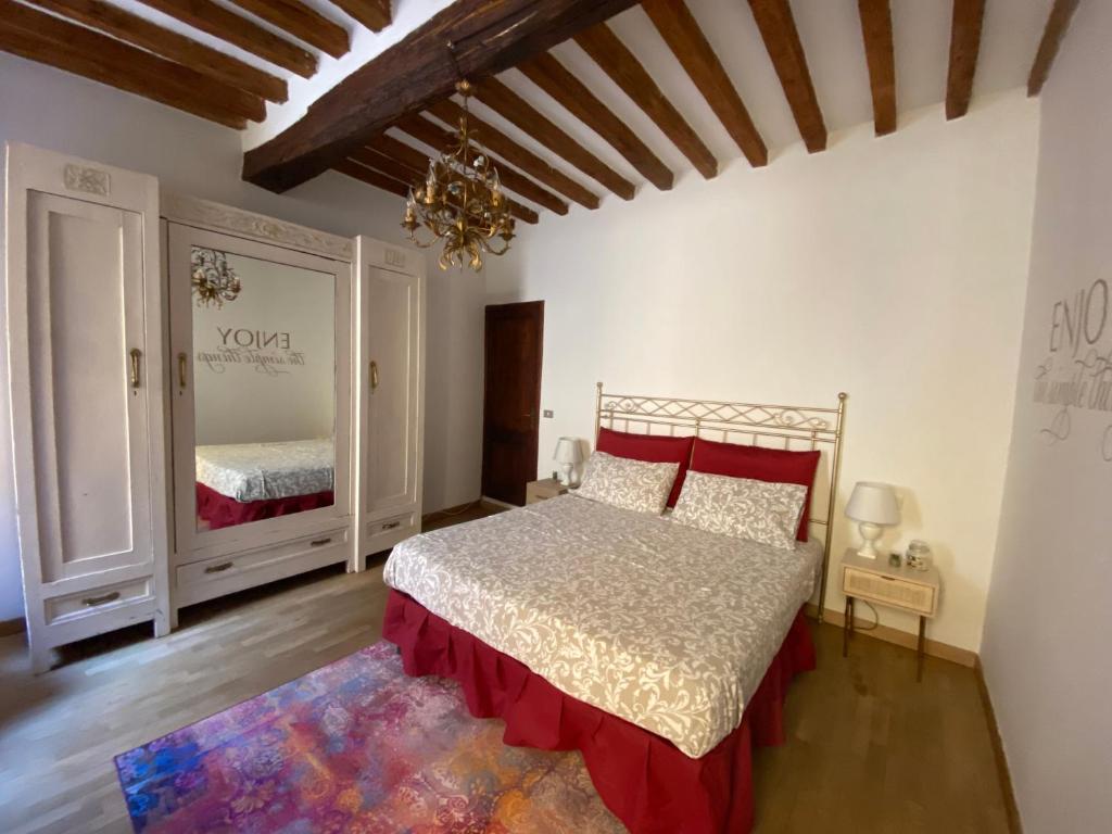 een slaapkamer met een groot bed en een spiegel bij del posto in Parma