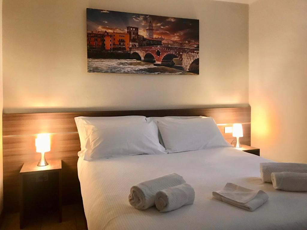 a bedroom with a bed with towels on it at Verona Apartments & Rooms Porta Vittoria in Verona