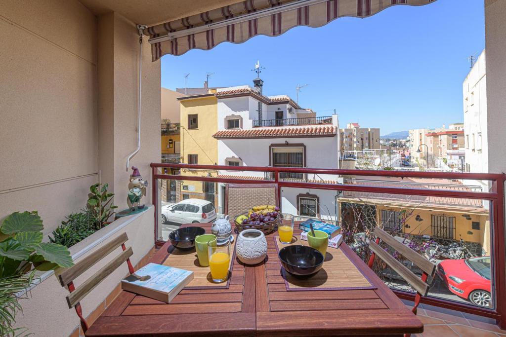 una mesa en un balcón con vistas a la ciudad en La Casa de Bebita en Fuengirola
