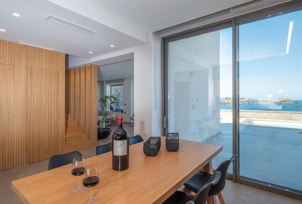 a room with a table with a bottle of wine on it at Ligaria Mare in Agia Pelagia