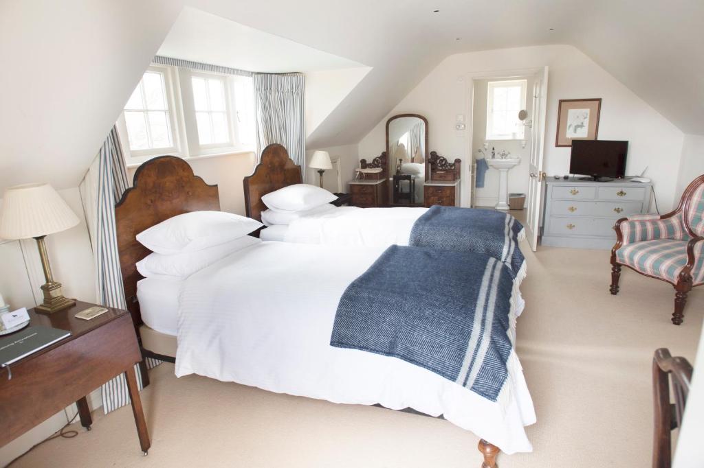 Un dormitorio con una cama blanca con una manta azul. en The Countryside Annexe en Pulborough