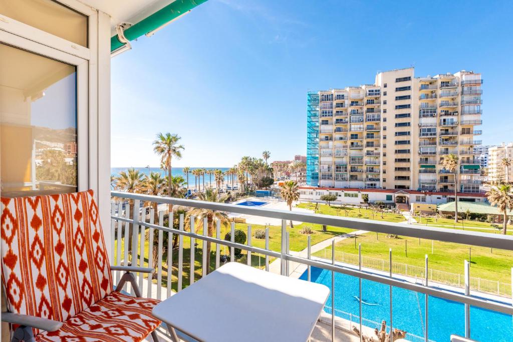 a balcony with a view of the beach and buildings at Sunny Seaside Apartment in Arroyo de la Miel