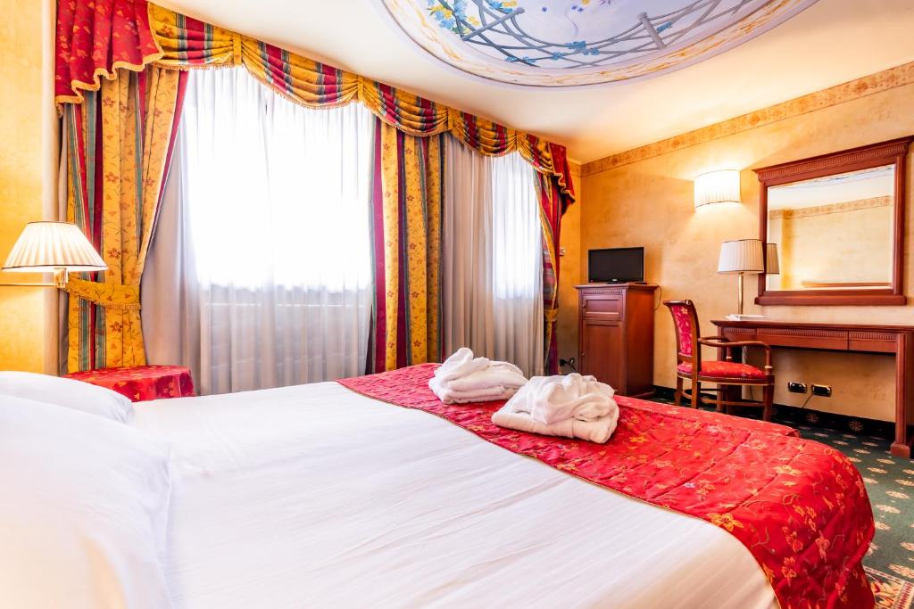 Postel nebo postele na pokoji v ubytování Hotel Cristallo