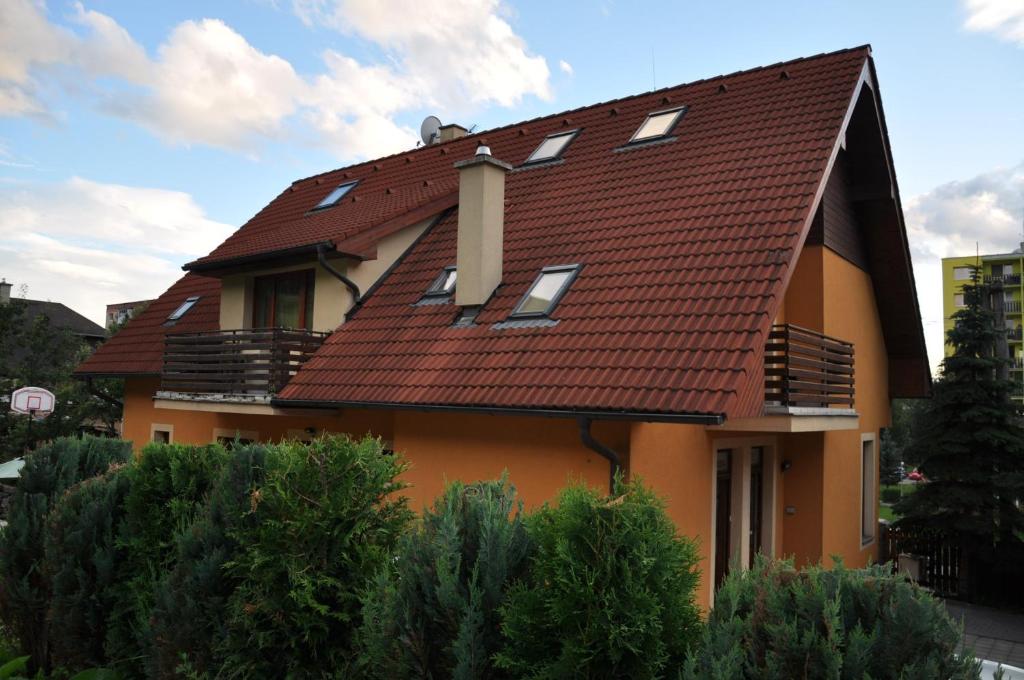 a house with a brown roof and some trees at Privat Podlesom in Kežmarok