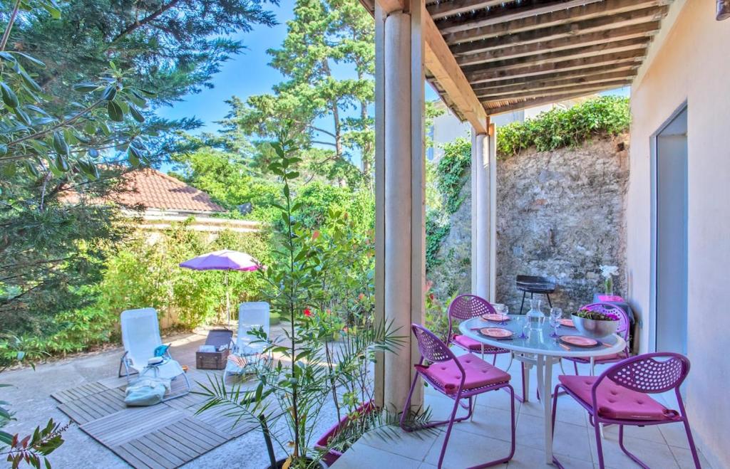 un patio avec une table, des chaises et un parasol dans l'établissement Casa Estel - Blue apartment in downtown of Erbalunga, à Brando