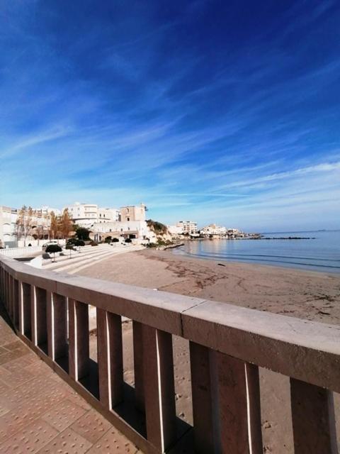 Blick auf einen Strand mit Gebäuden und das Meer in der Unterkunft Elegante Appartamento Lungomare Kennedy in Otranto