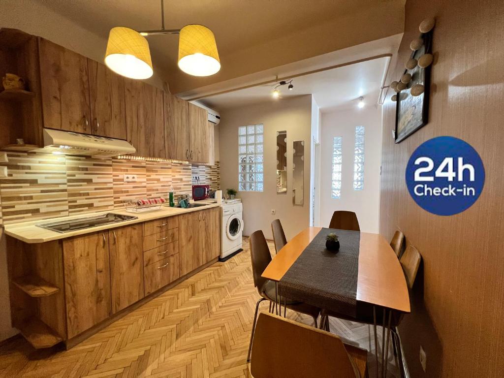 Bartók Apartment في سيجد: مطبخ مع طاولة خشبية وطاولة وكراسي