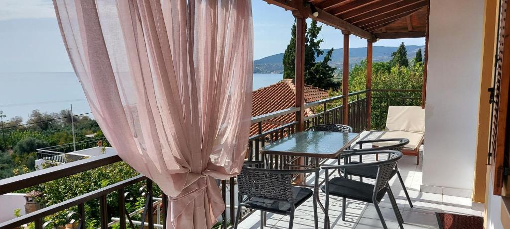 a balcony of a house with a table and chairs at Sipsas Villas in Koroni