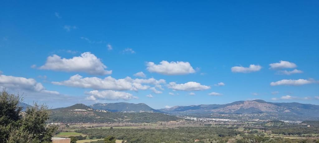 una vista de las montañas y un cielo azul con nubes en Charmant T2 en Bastelicaccia