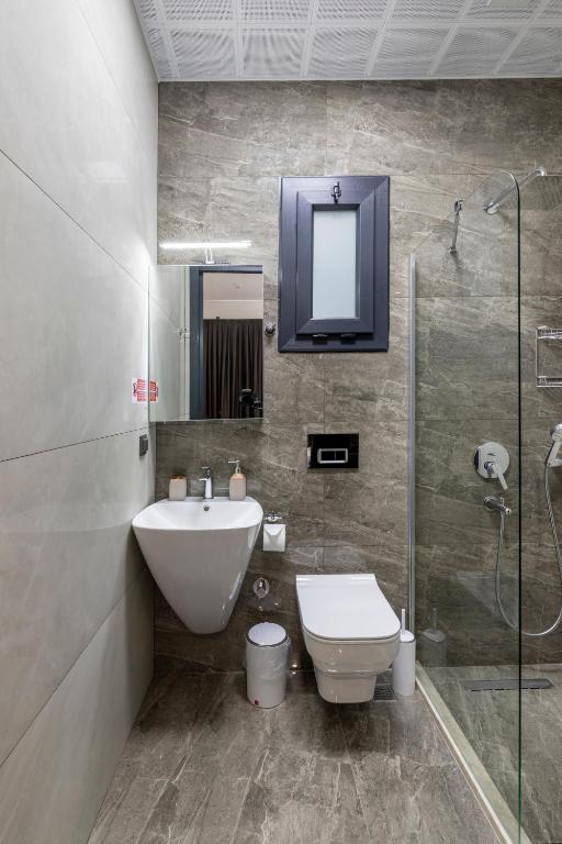 a bathroom with a sink and a toilet and a shower at Born in Blue in Kaş