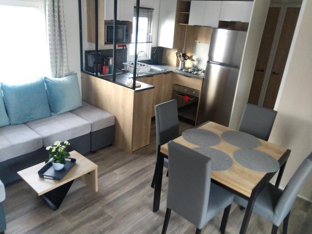 a kitchen and a living room with a table and chairs at mobilhome 3 chambres in Litteau