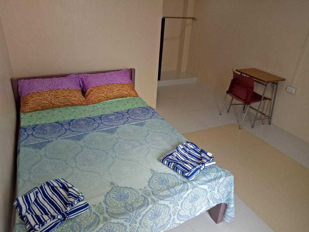 ein Schlafzimmer mit einem Bett, einem Tisch und einem Stuhl in der Unterkunft BM Island Inn in Bantayan