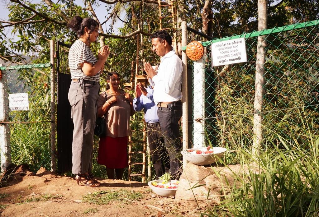 un grupo de personas de pie junto a una valla en Kandy Nature Resort en Ampitiya