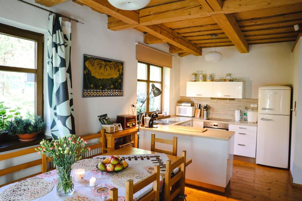 a kitchen with a table and a white refrigerator at Chata u Gregora v Slovenskom raji in Smižany