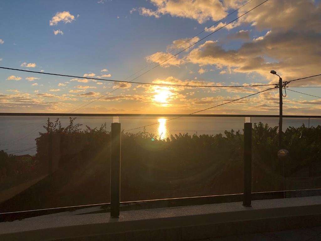 a sunset over the water with the sun in the sky at Calheta Ocean View Apartment 2 in Estreito da Calheta