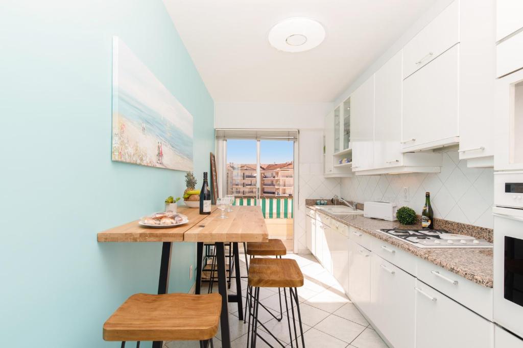 a kitchen with a table and some stools at ELEGANCE YourHostHelper in Le Cannet