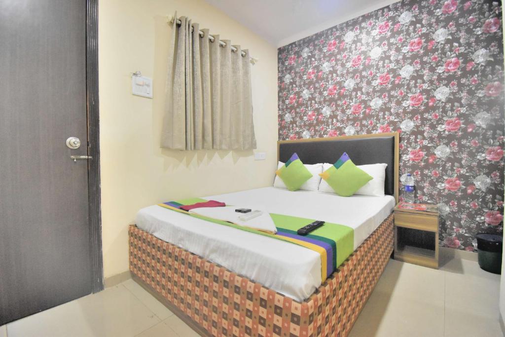 a bedroom with a bed with a floral wall at BALAS RESIDENCY in Mumbai