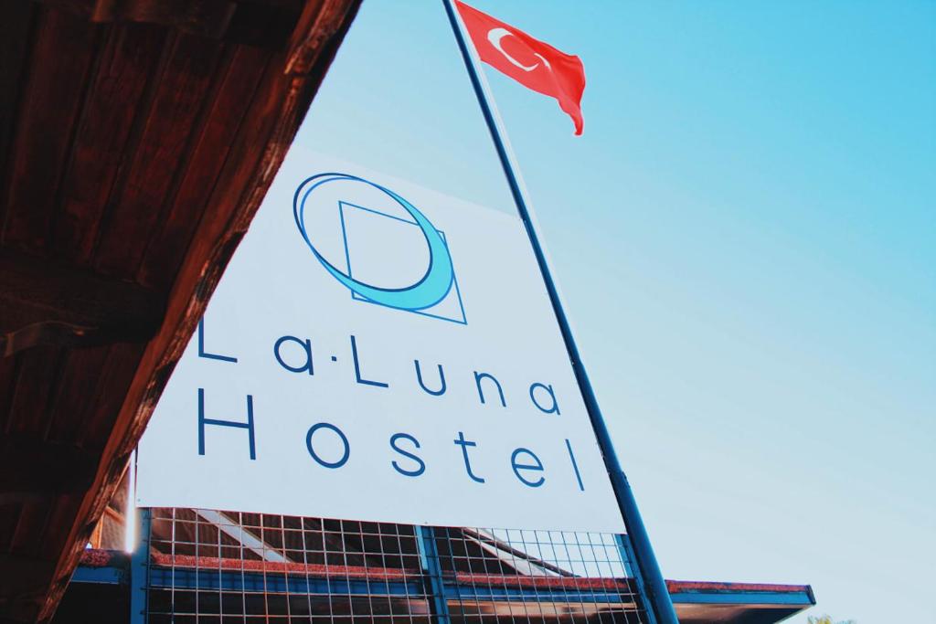 La Luna Hostel في بودروم: علم فوق مبنى عليه لافته