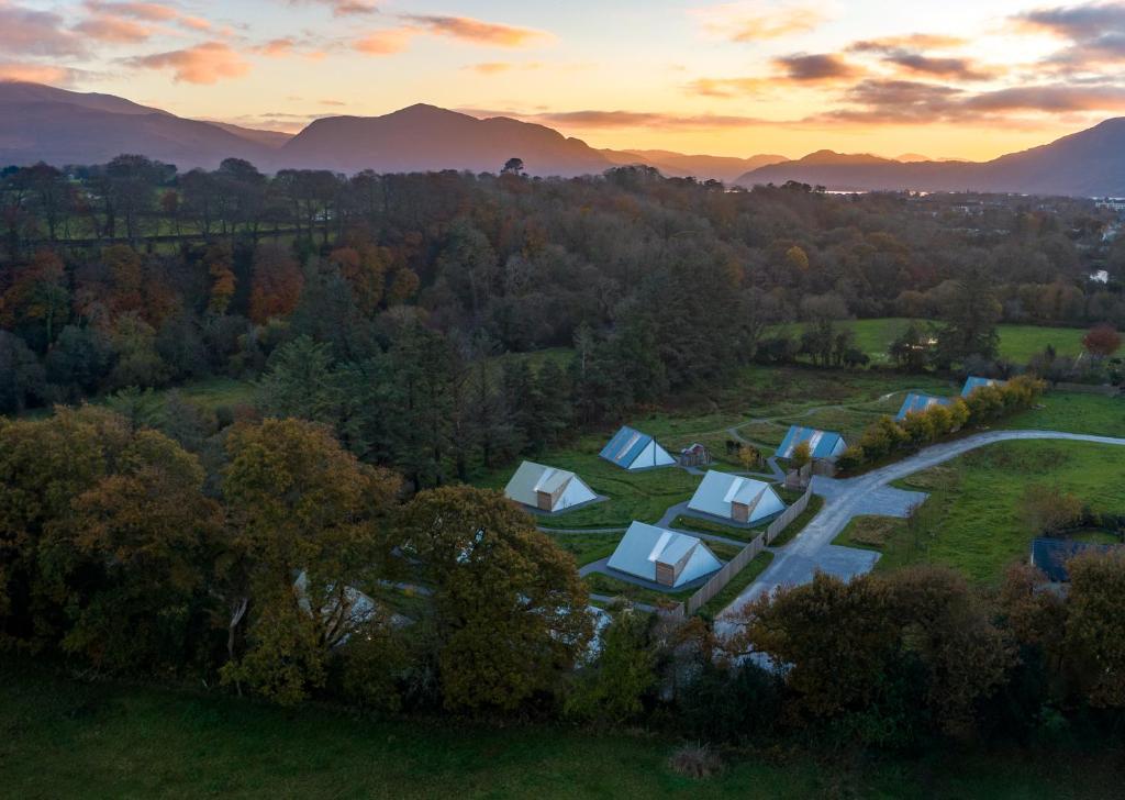 einen Luftblick auf einen Bauernhof mit Bäumen und Bergen in der Unterkunft Killarney Glamping at the Grove, Suites and Lodges in Killarney