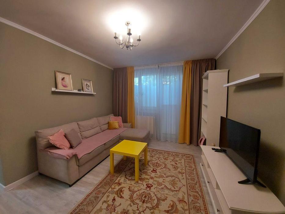 een woonkamer met een bank en een tafel bij Apartament Marasesti in Piteşti