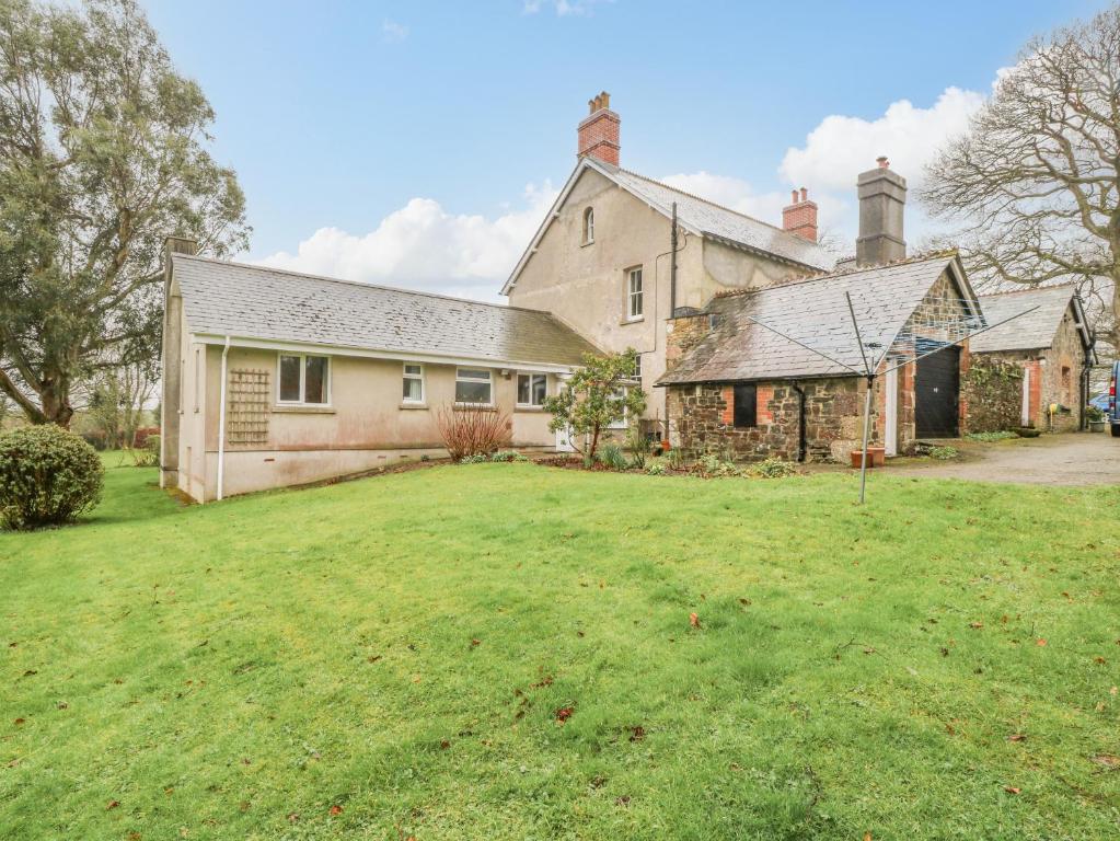 una casa vieja con un patio delante en Orchard End, en Boyton