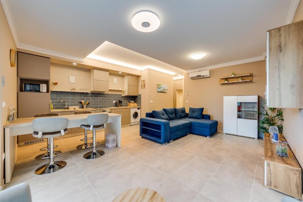 a kitchen and living room with a blue couch at Forest Földvár Apartmanok By BLTN in Balatonföldvár