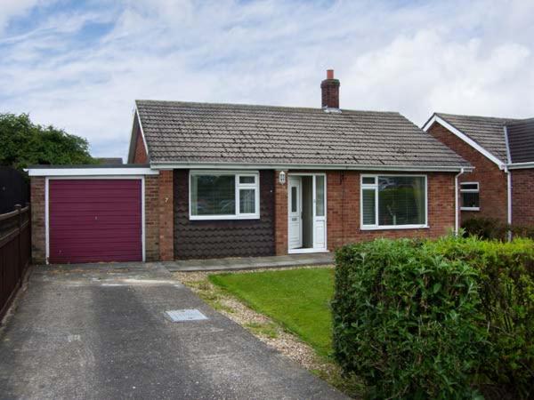 una casa in mattoni con garage rosso di Sunnyside Cottage a Skegness