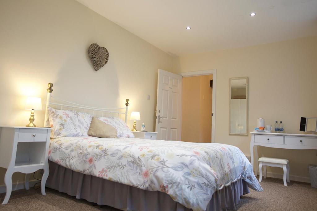 a bedroom with a bed and a desk and a mirror at Trelaske Manor B&B in Launceston
