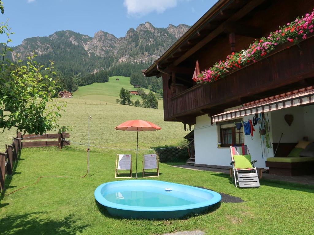 a hot tub in a yard next to a house at Apartment Theresia - APH310 by Interhome in Alpbach