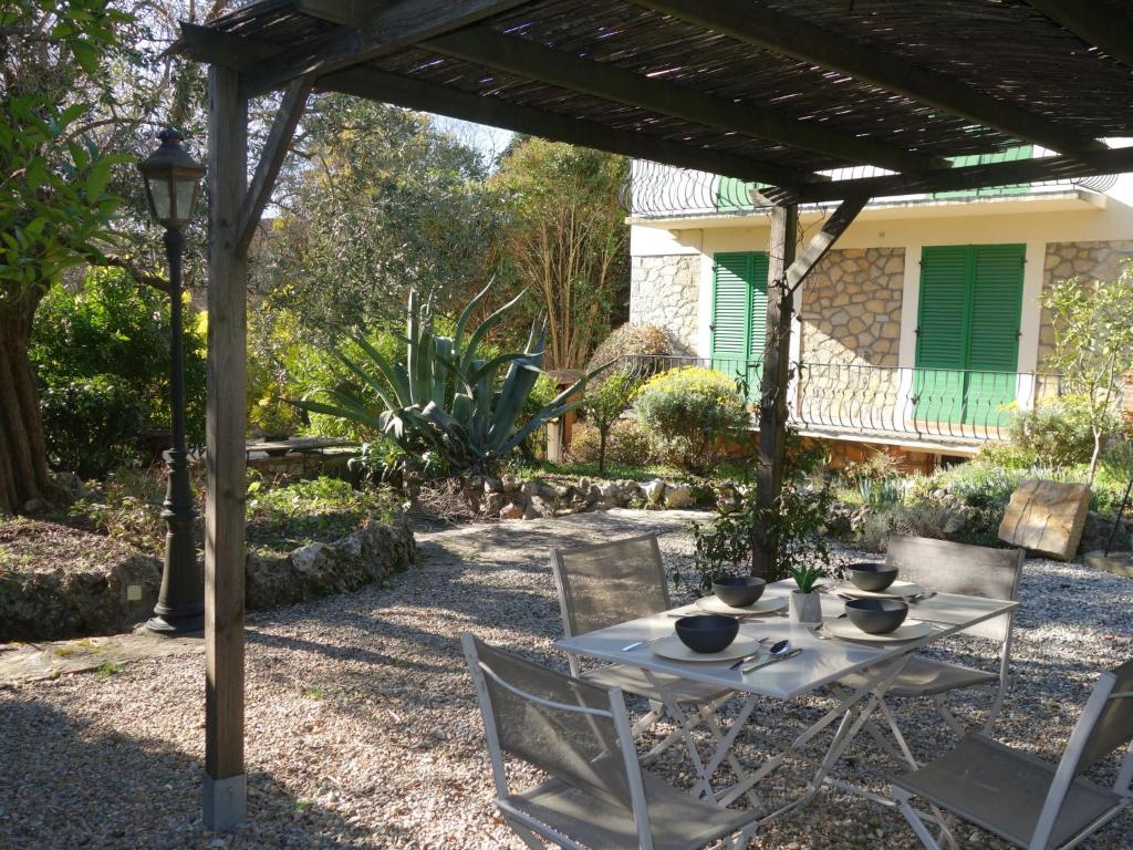 a table and chairs under a pergola in a yard at Apartment Lou Mi-Re by Interhome in Cannes