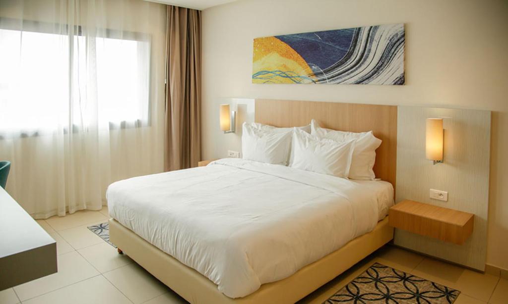 a bedroom with a large bed and a window at Zephyr Agadir in Agadir