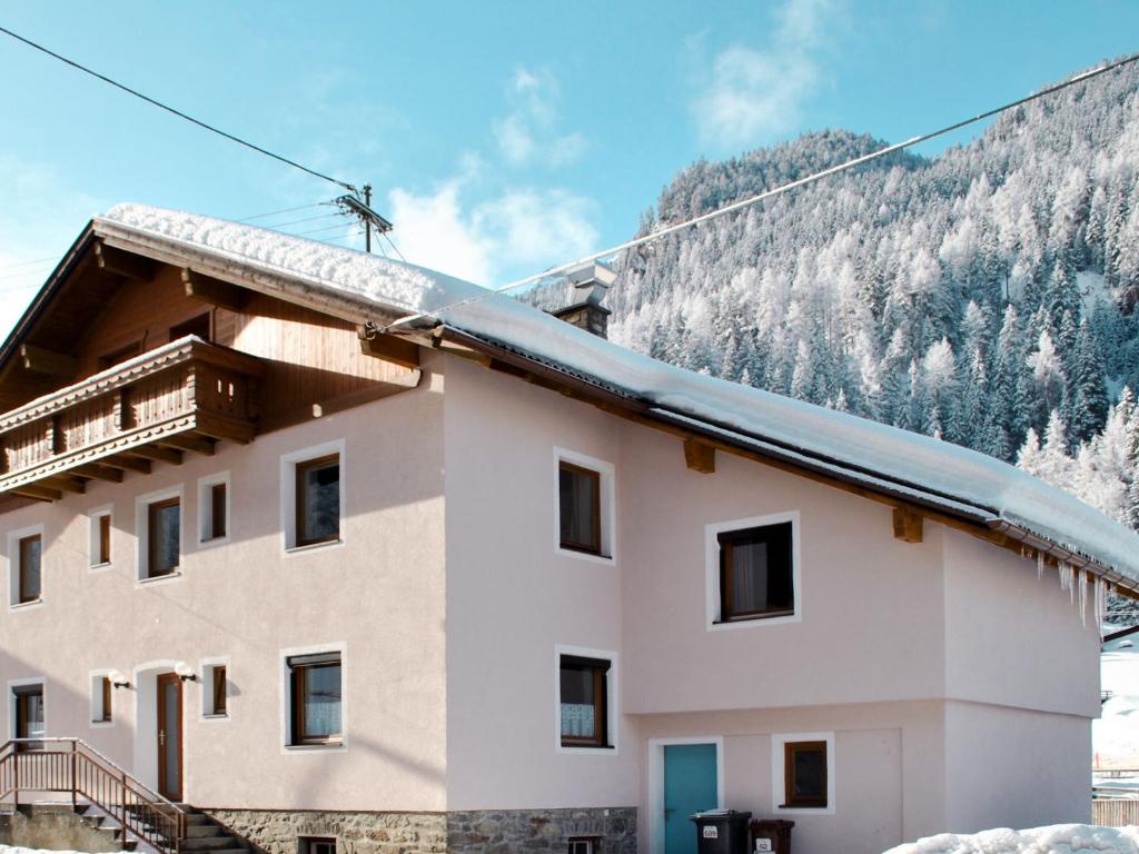 a building with a snow covered mountain in the background at Holiday Home Gaugg by Interhome in Sankt Leonhard im Pitztal