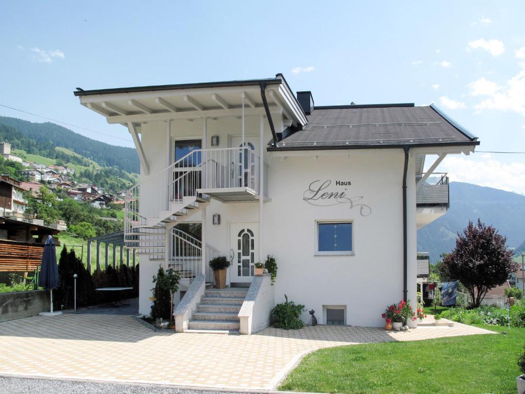 - un bâtiment blanc avec une terrasse couverte et des escaliers dans l'établissement Apartment Leni - FIE150 by Interhome, à Fließ