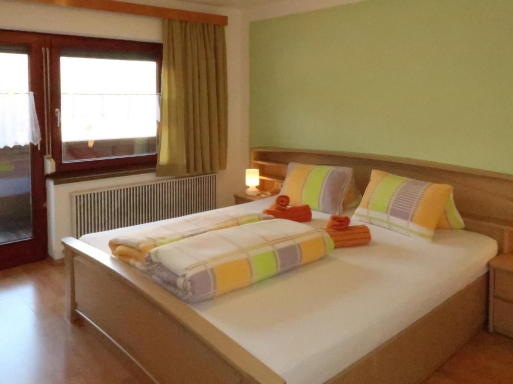 sypialnia z dużym łóżkiem i kolorowymi poduszkami w obiekcie Apartment Zechner-3 by Interhome w mieście Tobadill
