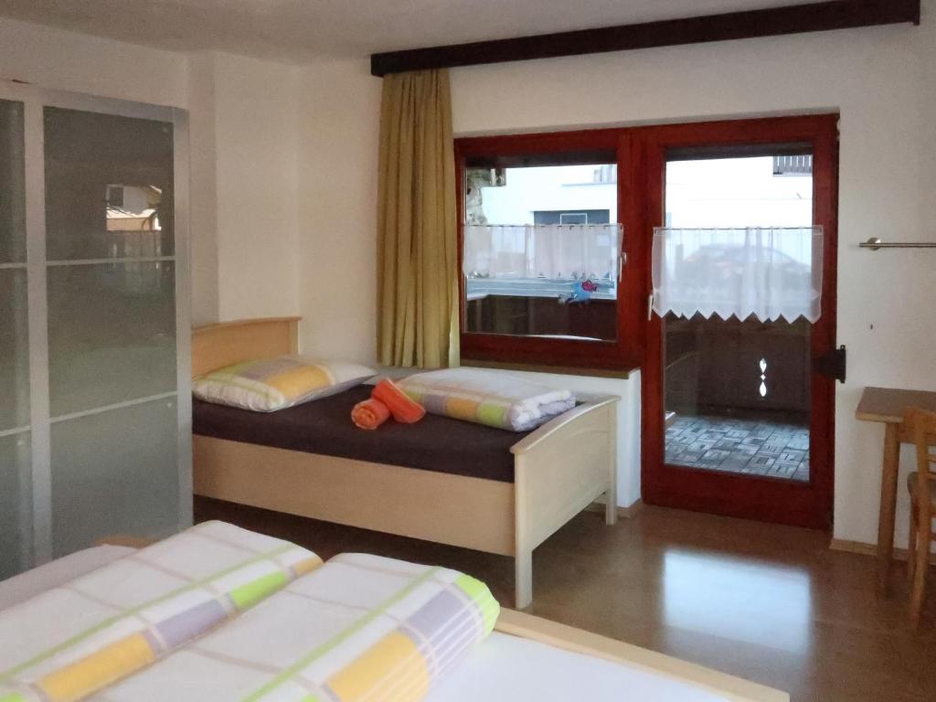 sypialnia z 2 łóżkami, oknem i drzwiami w obiekcie Apartment Zechner-3 by Interhome w mieście Tobadill